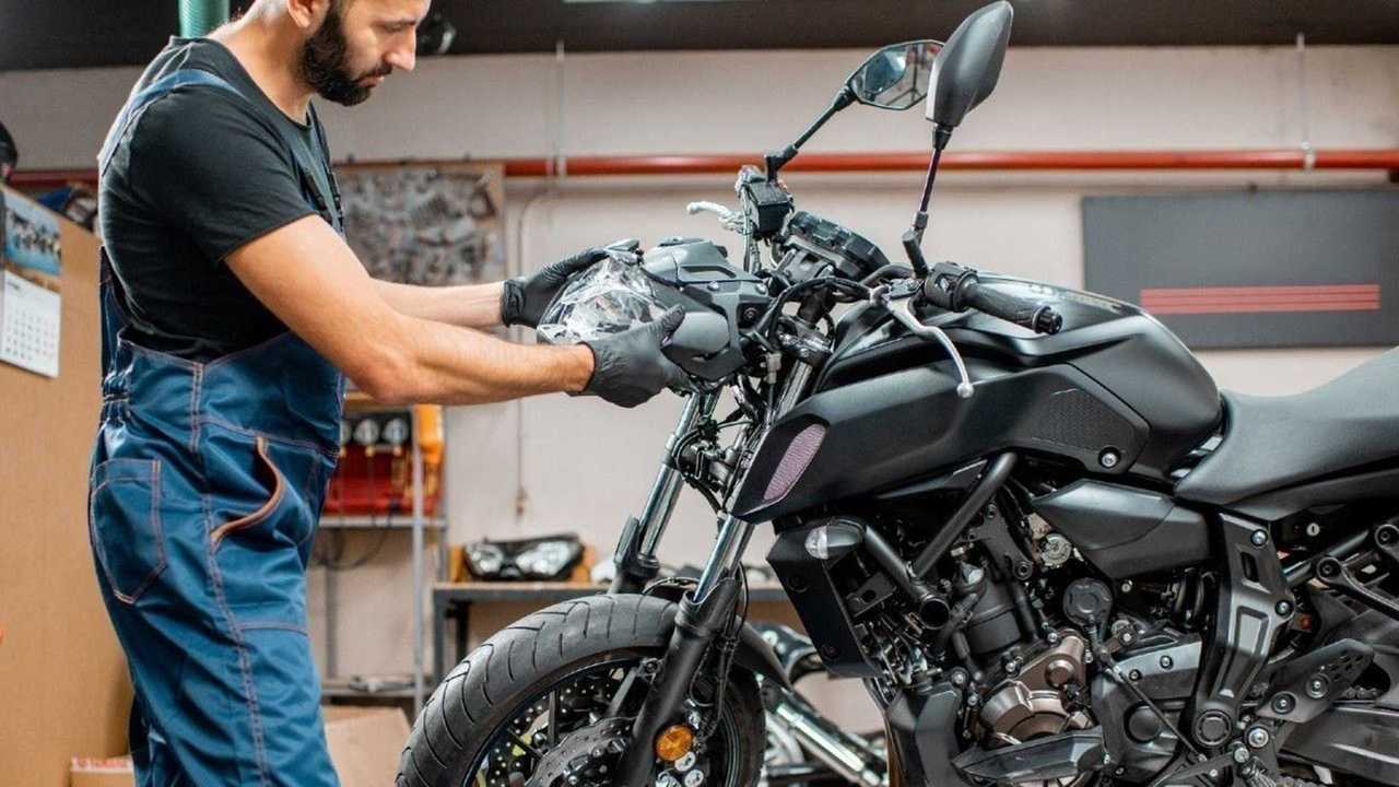 Un homme qui fait la révision d'une moto