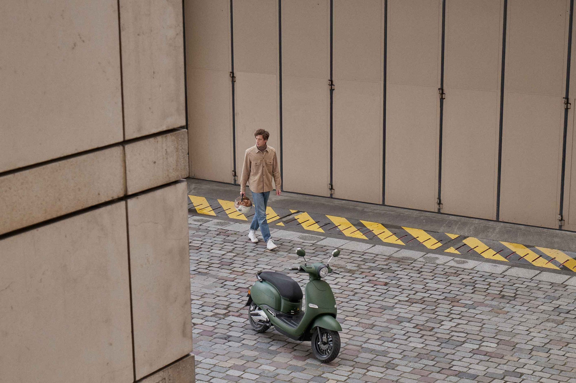 Un homme qui marche vers son scooter garé